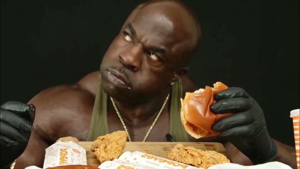 Негр ест бургер