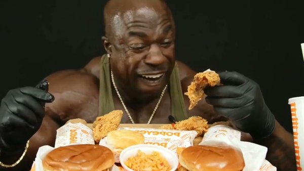 Черный качок ест бургеры и курицу