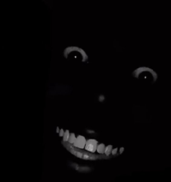 Черный человек улыбается в темноте