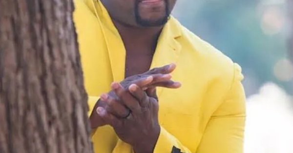 Негр в желтом костюме за деревом