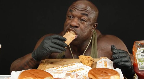 Негр ест бургер