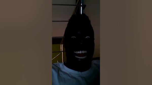 Негр улыбается в темноте