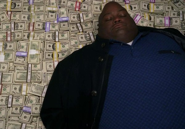 Негр лежит на деньгах