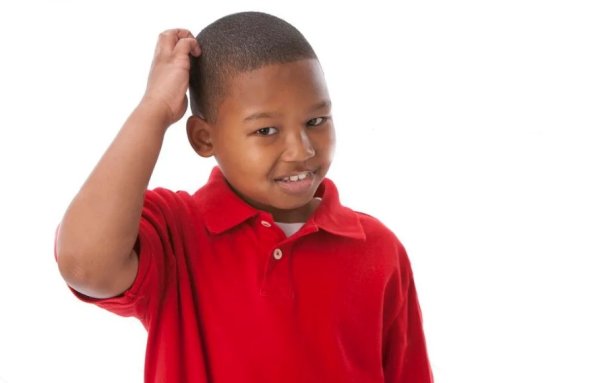 Чернокожий мальчик чешет затылок
