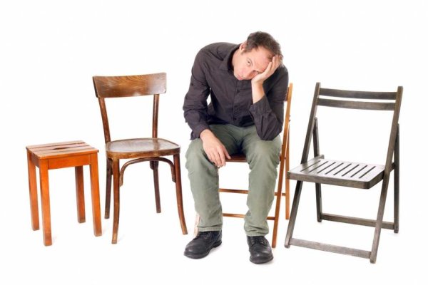 Человек сидит на стуле ъ