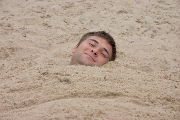 Парень лежит на песке