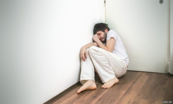 Мужчина плачет в углу
