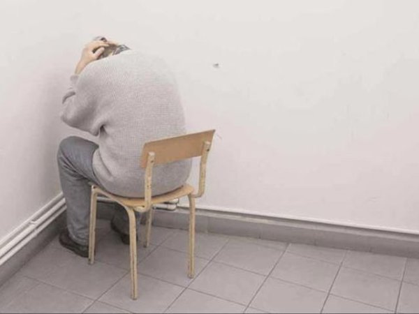 Человек плачет в углу