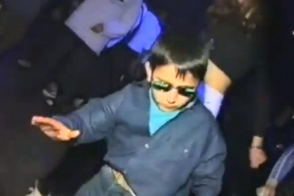 Мальчик танцует в клубе в очках