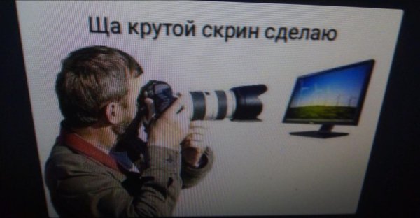 Человек фоткает монитор фотоаппаратом