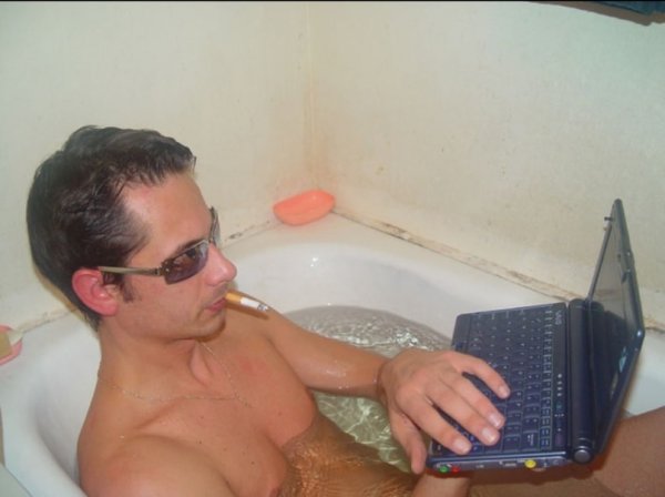 Мужчина в ванне с ноутбуком