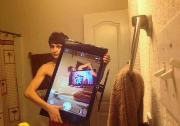 Мужчина фотографируется в зеркале