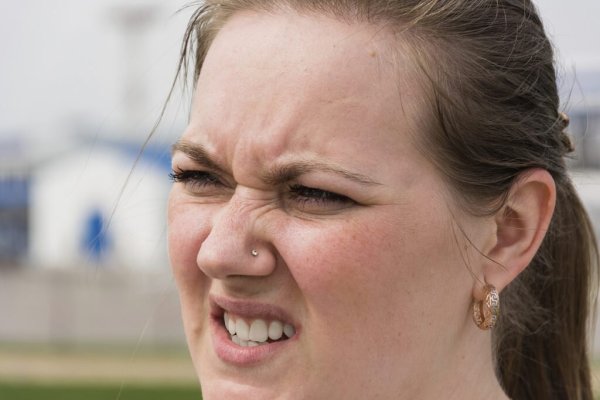 Девушка щурится на солнце