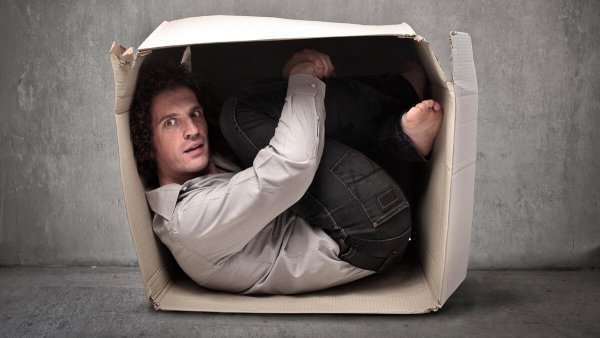 Человек сидит в коробке