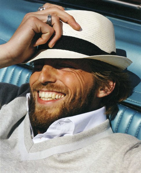 Парень в шляпе улыбается