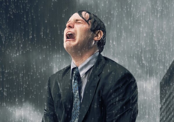 Мужчина плачет под дождем