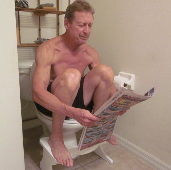 Мужчина стдит на унитаз е