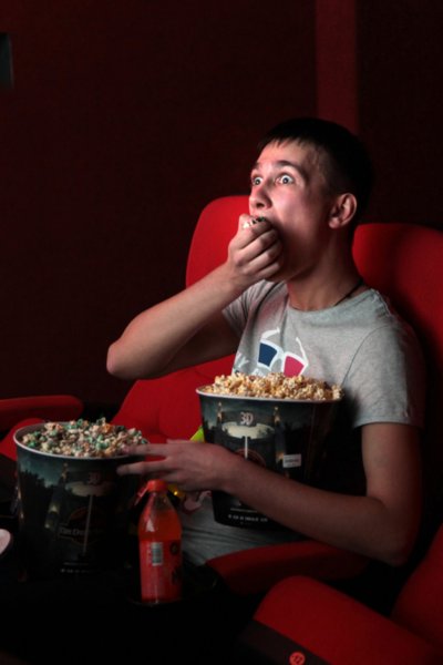 Человек ест попкорн