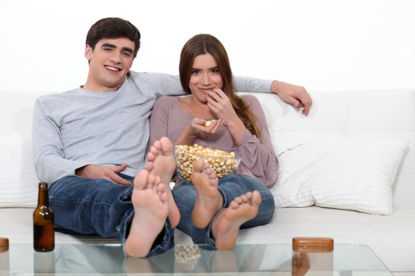 Пара сидит на диване в обнимку