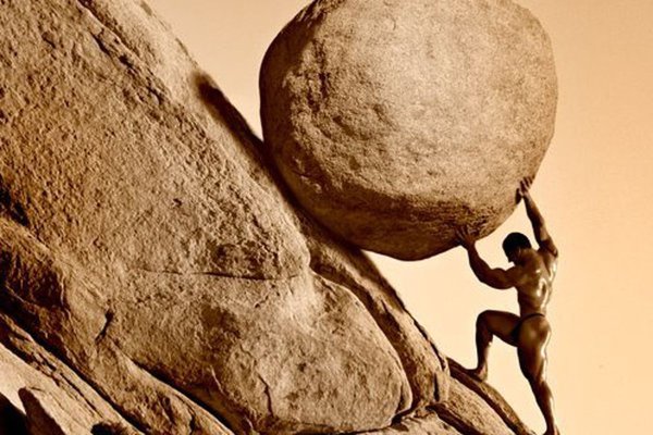 Человек толкает камень в гору