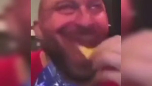 Лысый мужик улыбается и ест чипсы