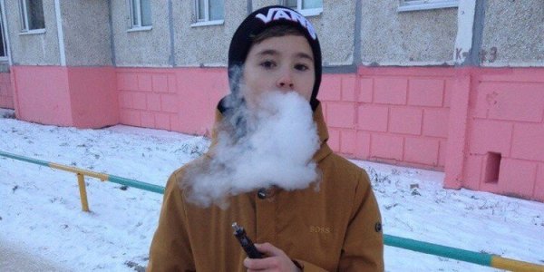 Мальчик курит вейп