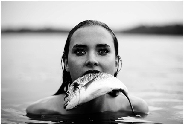 Девушка с рыбой во рту