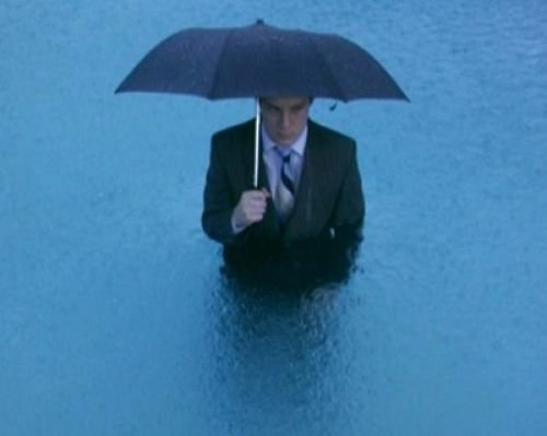 Мужчина с зонтом под дождем