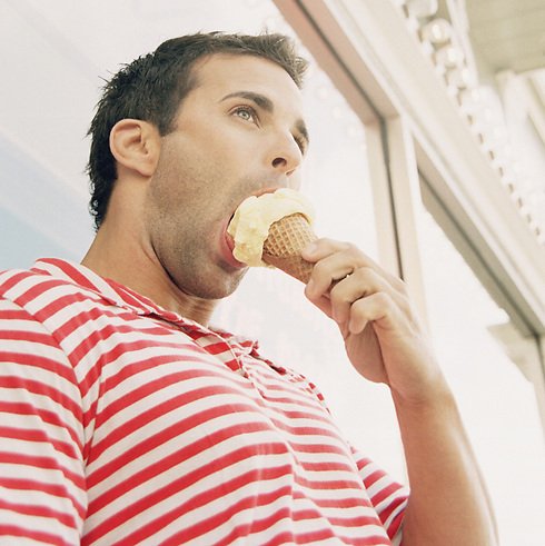 Мужчина ест мороженое
