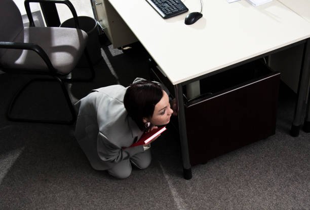 Человек прячется под столом