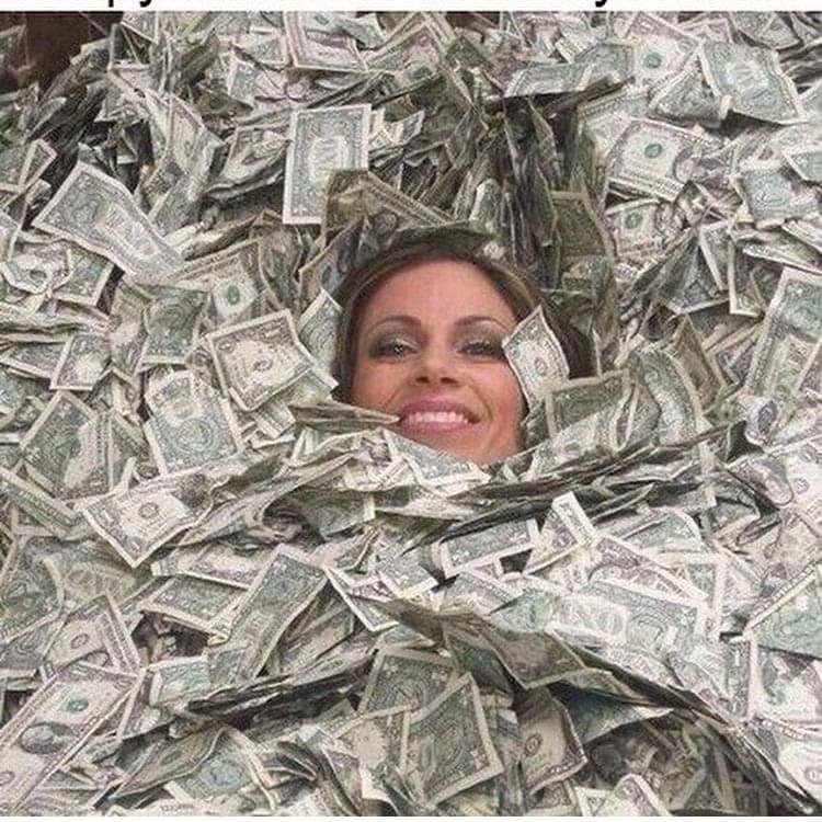 Девушка лежит в деньгах