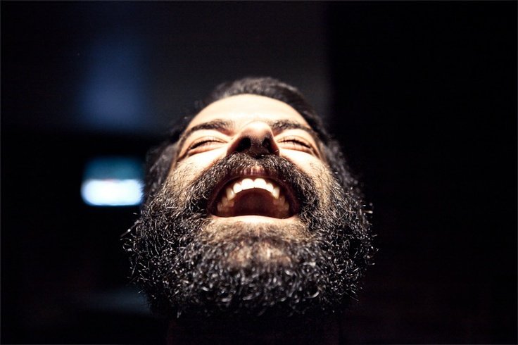 Мужчина с бородой улыбается