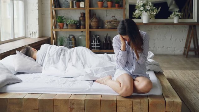 Женщина грустна на кровати