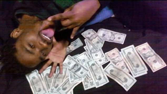 Негр лежит на деньгах