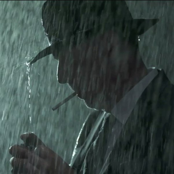 Парень курит под дождём