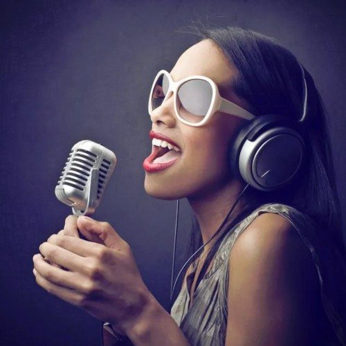 Поет в микрофон