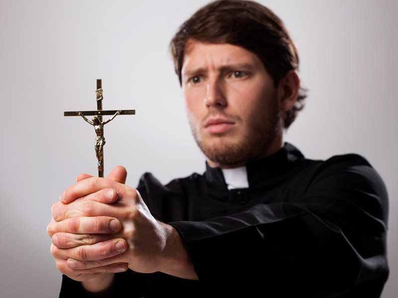 Священник с крестом в руке