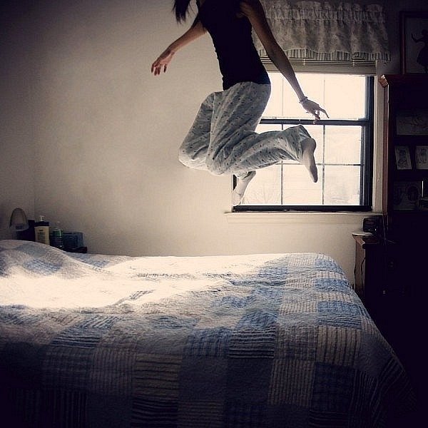 Девушка танцует на кровати
