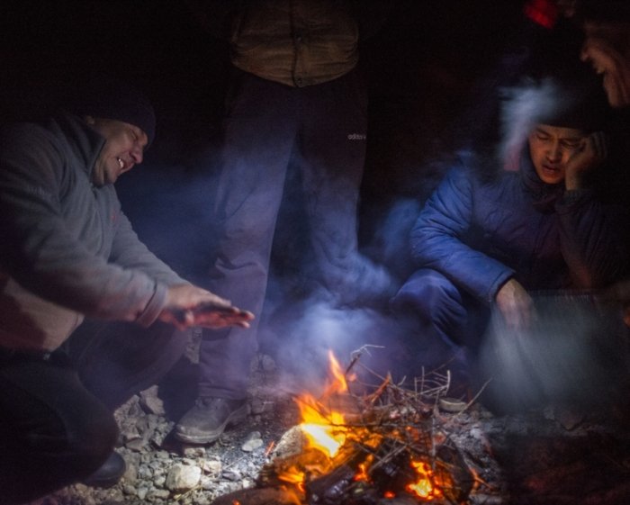 Человек греется у костра зимой