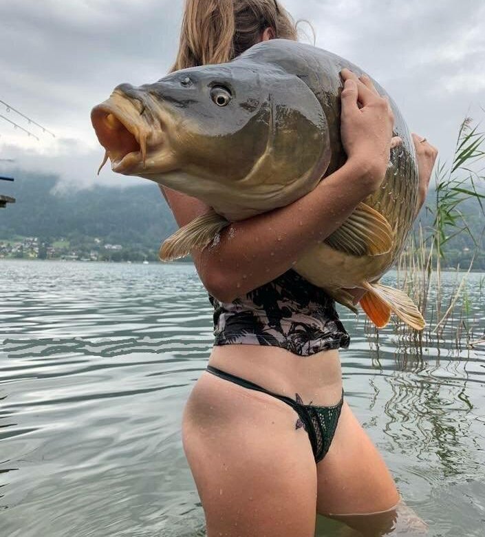 Девушка с рыбой в зубах