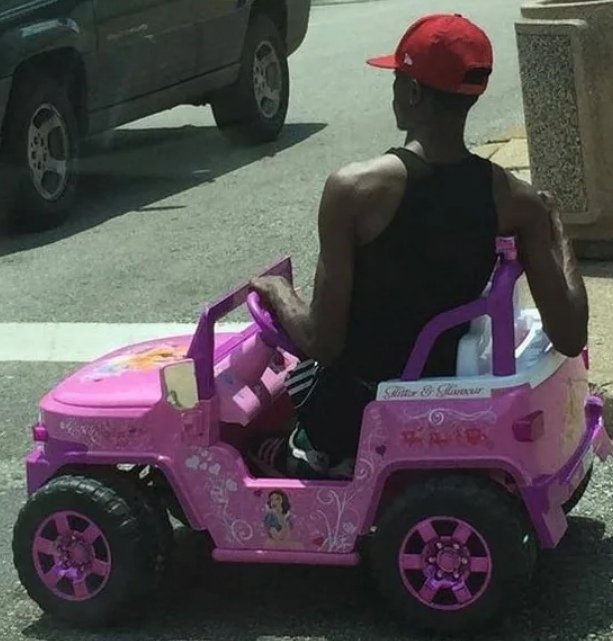 Парень в детской машинке