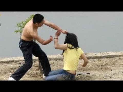 Мужчина тащит женщину за волосы