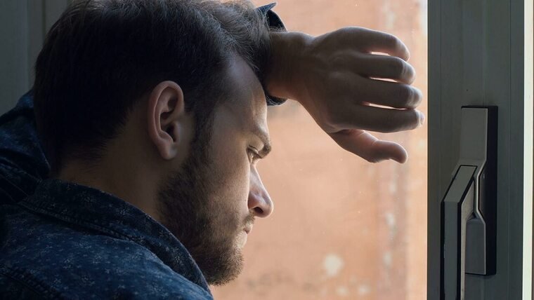 Мужик плачет у окна