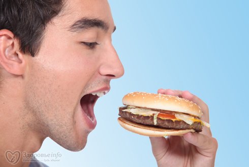 Мужчина ест бургер
