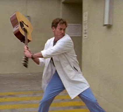 Человек бьет гитарой