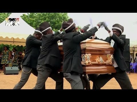 Негры несут гроб и танцуют