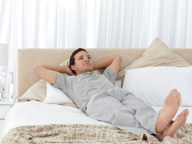 Человек лежачи на кровате