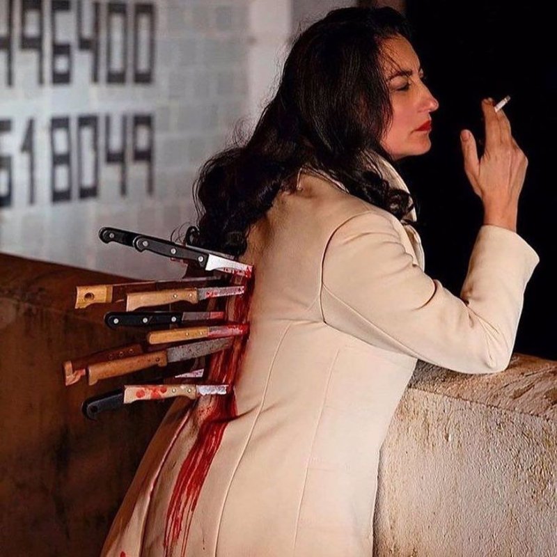 Женщина с ножами в спине курит