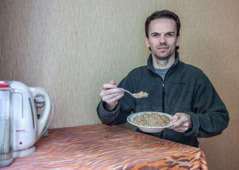 Мужчина ест кашу