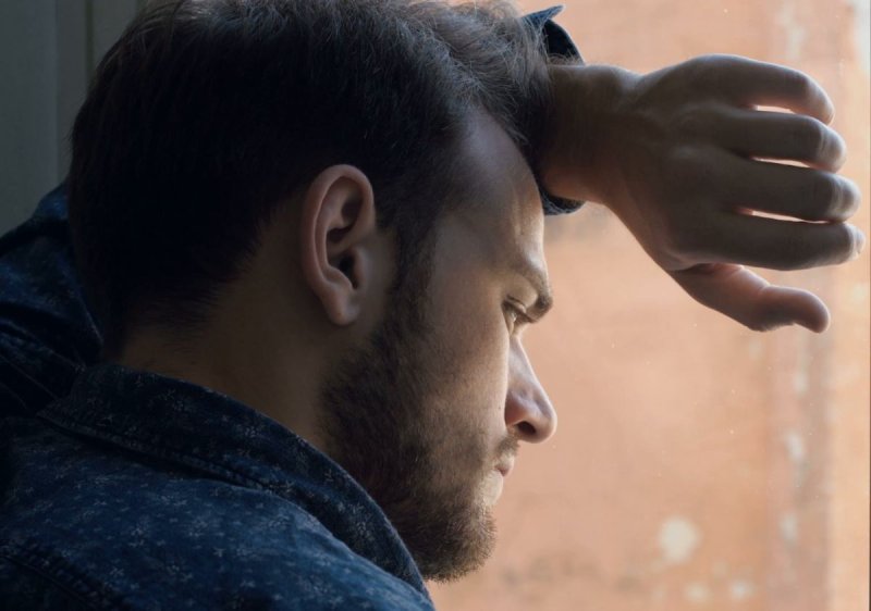 Мужчина смотрит в окно